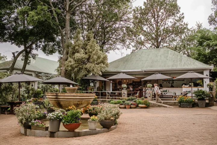 Alfresco bakery and garden surrounded by mature trees and colourful flowers
