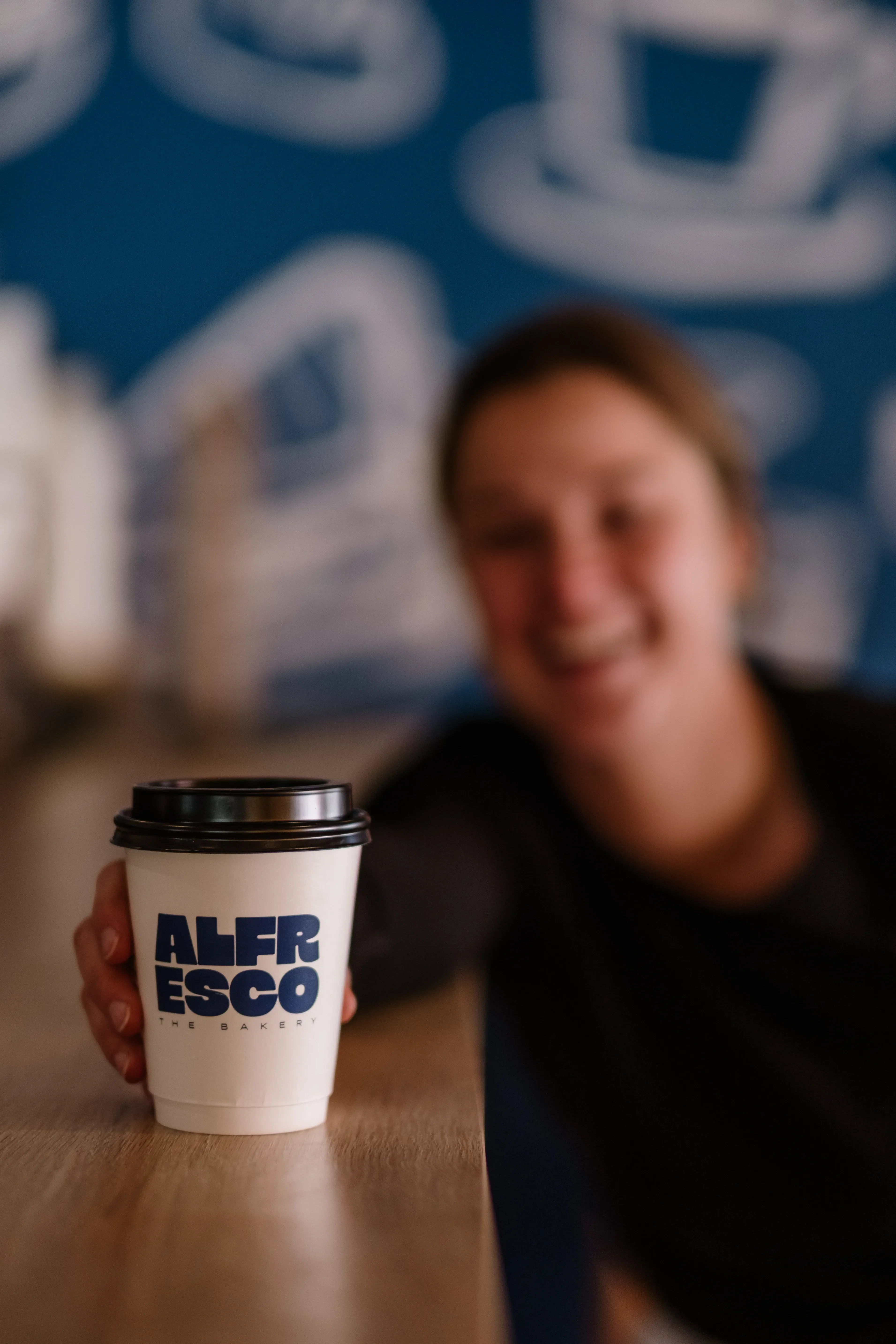 Coffee cup being held towards lens