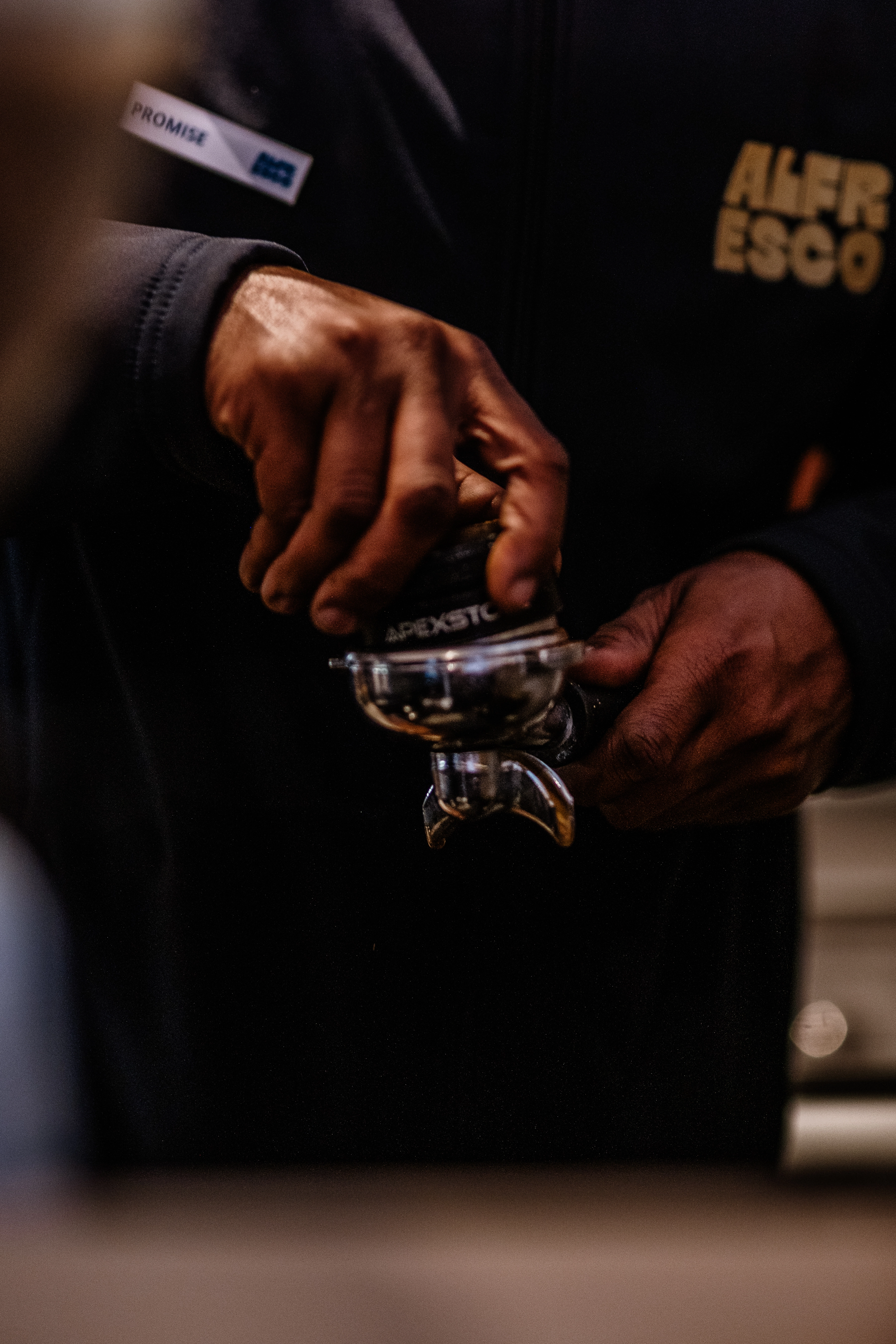 Alfresco employee grinding fresh coffee beans with professional equipment