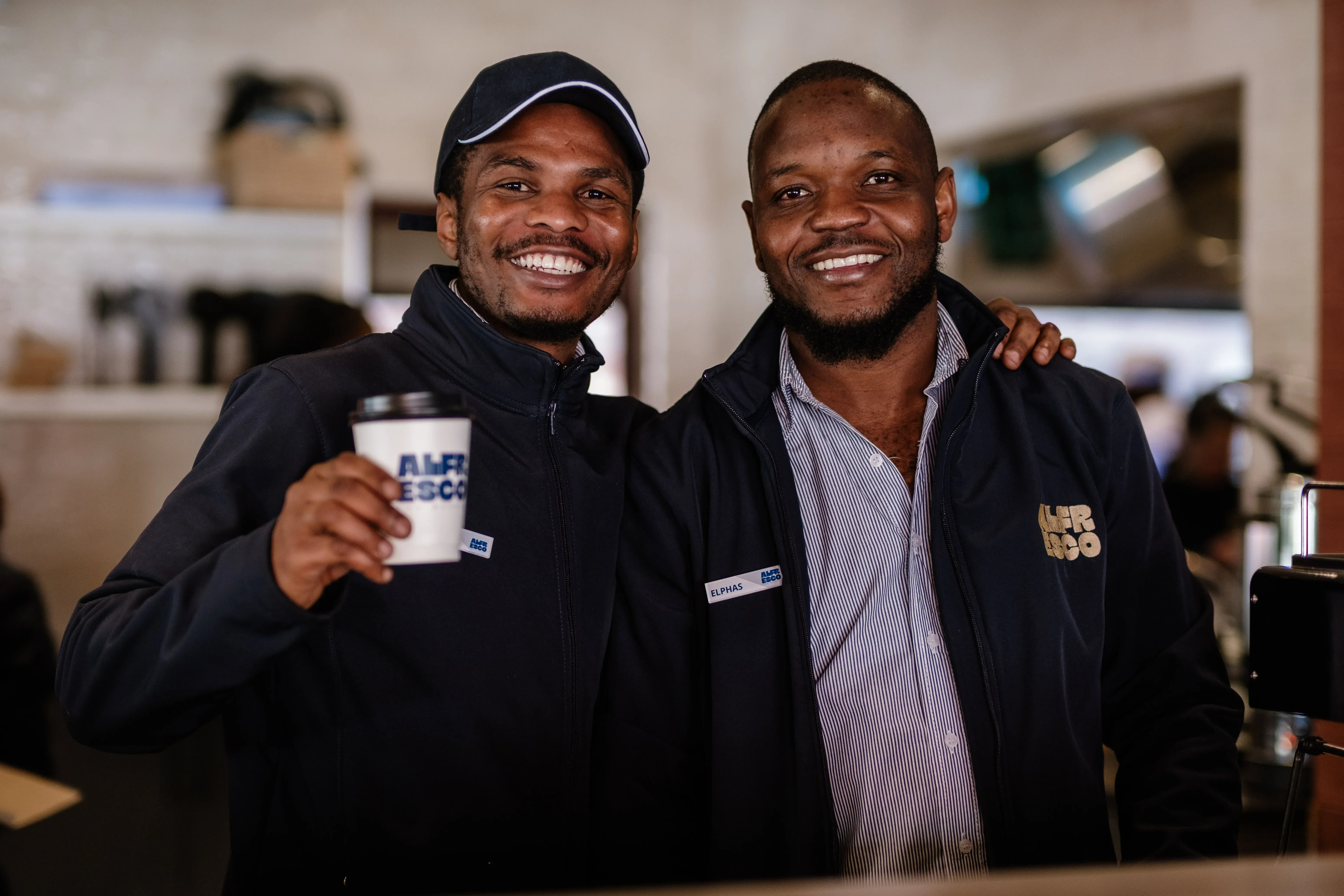 Employees smiling holding takeaway cup