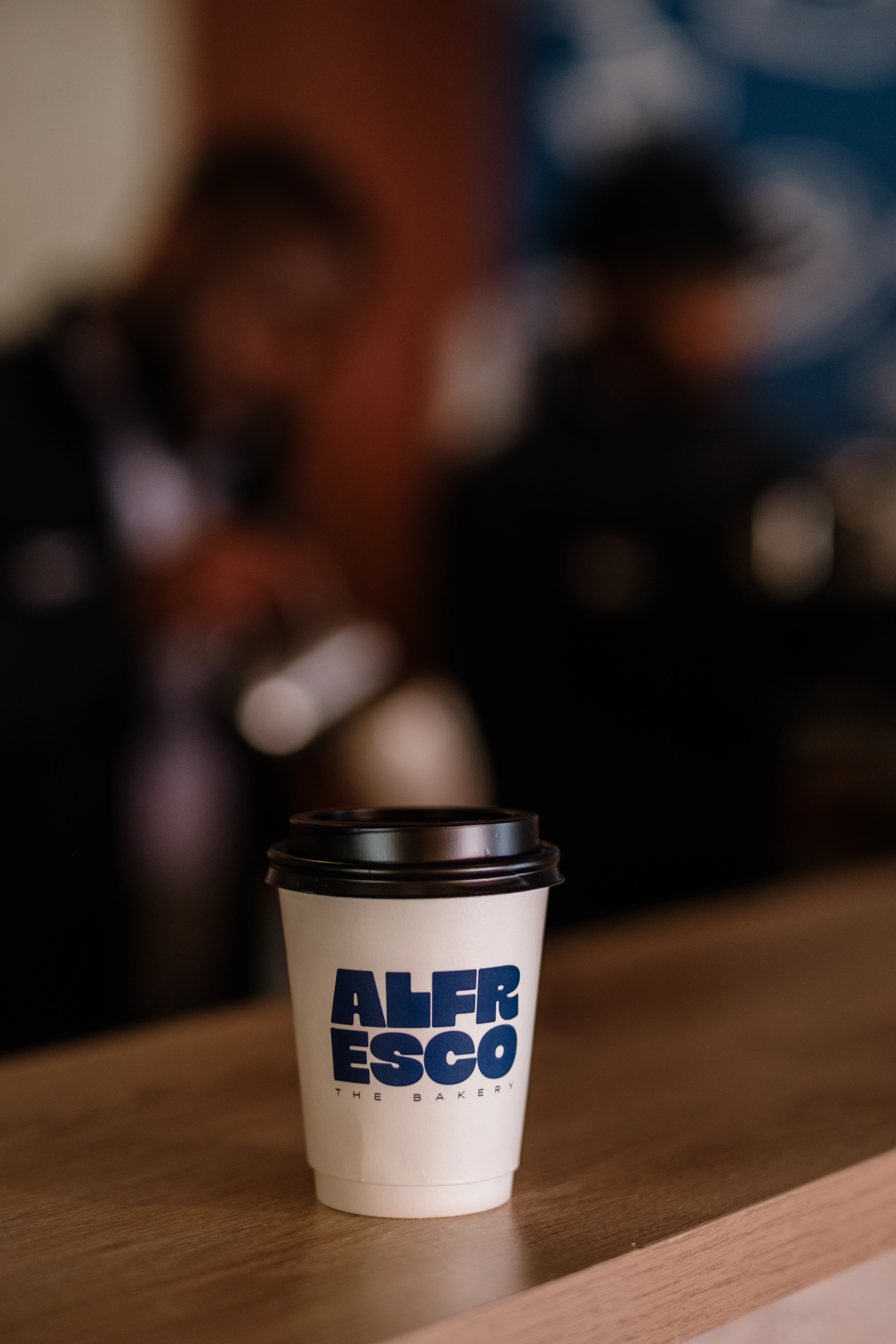 Alfresco branded takeaway cup with blurred background showcasing new branding