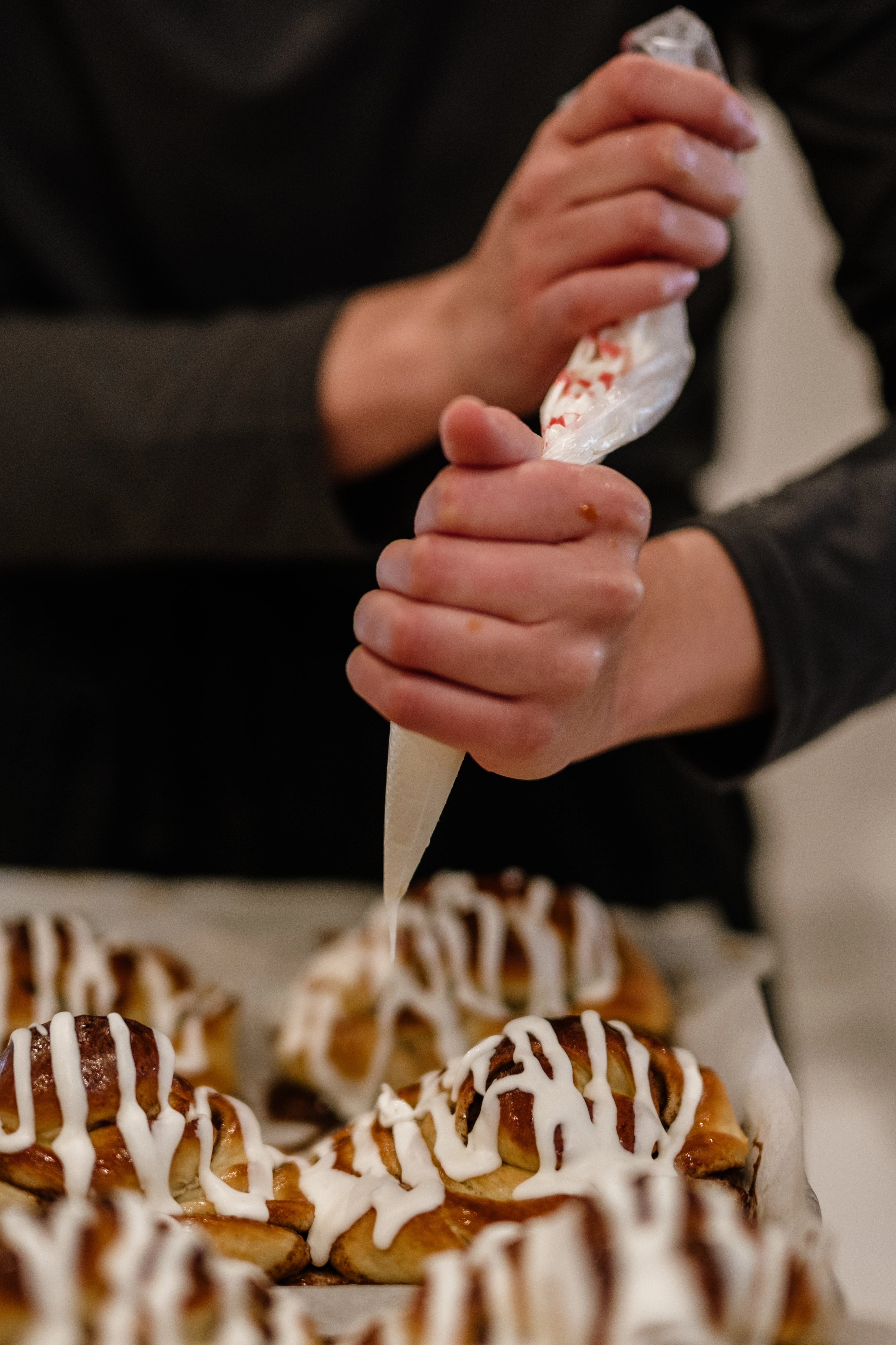 Employee putting cream on Chelsea buns