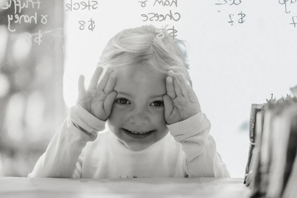 Young child smiling through the bakery glass