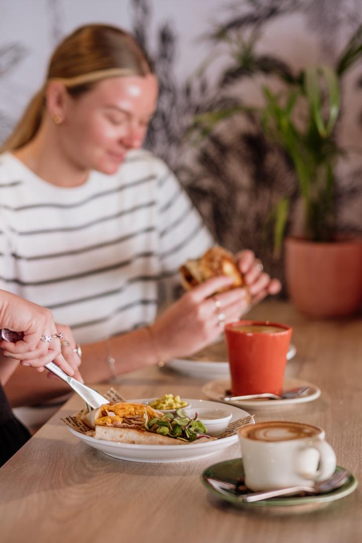 Alfresco team member proudly displaying our signature coffee cups